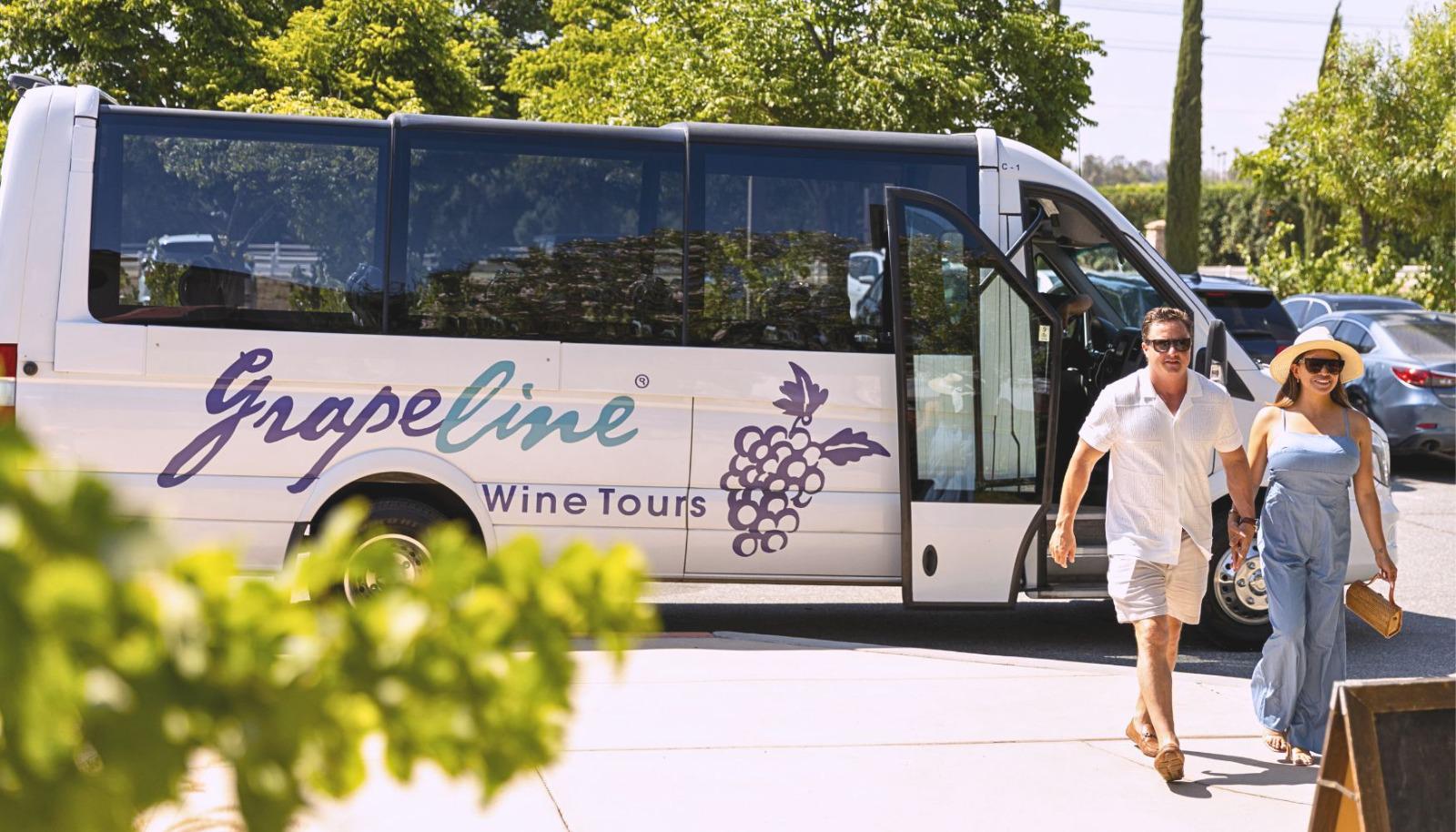 A vehicle parked outside a winery with a couple walking