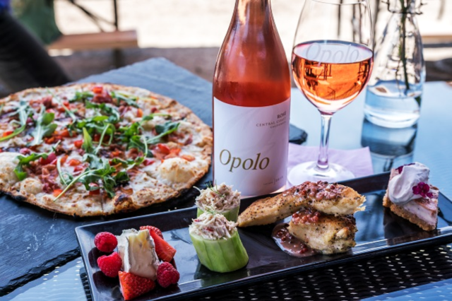 Dining at Opolo Vineyards in Paso Robles. Pictured wine bottle, pizza and small tappas style food options