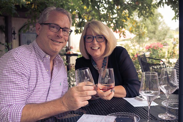 Happy couple toast while tasting on a Grapeline Wine Tour in Temecula, CA