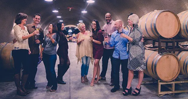 Friends toast and taste red wine in the cave at Oak Mountain Winery in Southern California