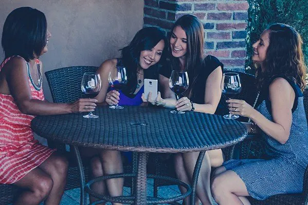 Ladies tasting wine and laughing at table