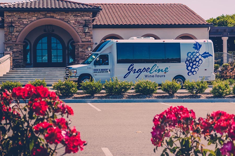 Grapeline shuttle at winery with red flowers