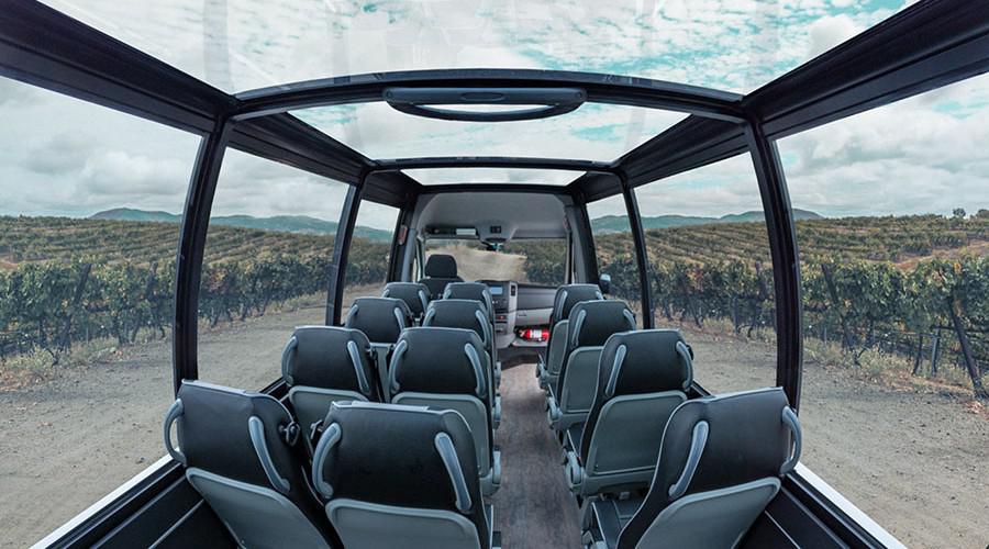 Interior view of a Mercedes convertible shuttle with a sprawling vista of vineyards 