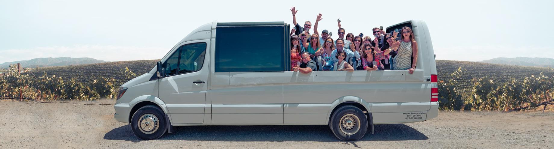 Guests pose for a photo with hands raised inside a convertible shuttle