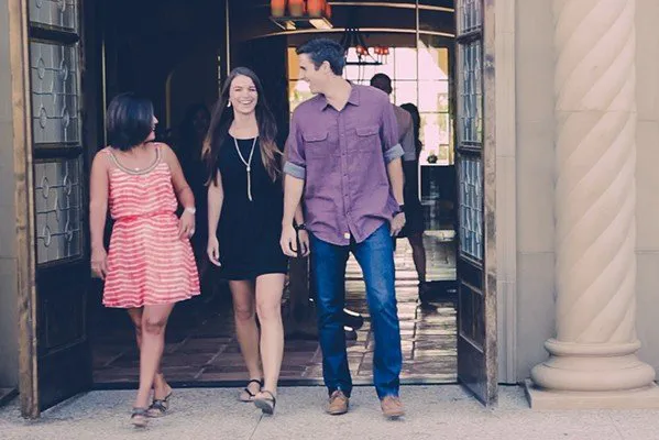 Three friends walking out of a door