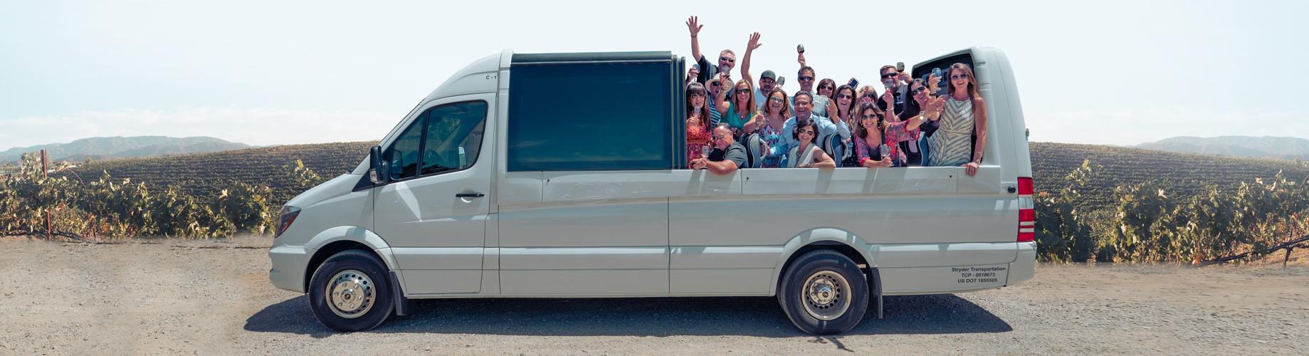 Guests pose for a photo with hands raised inside a convertible shuttle