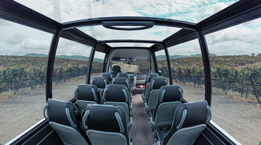 Interior view of a Mercedes convertible shuttle with a sprawling vista of vineyards 