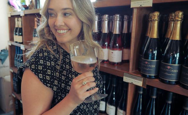 A girl looks away and smiles after tasting Wilson Creeks champagne