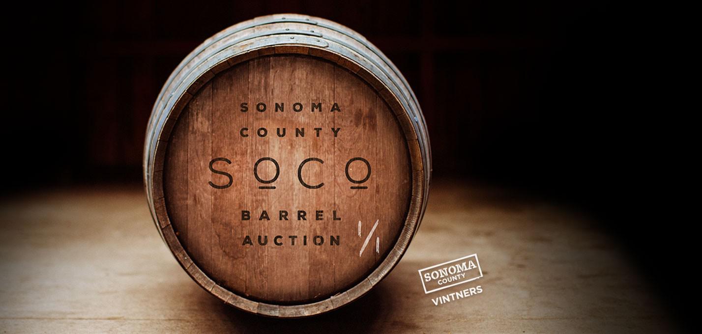a wine barrel in a dimly lit room bearing the Sonoma Barrel Auction markings
