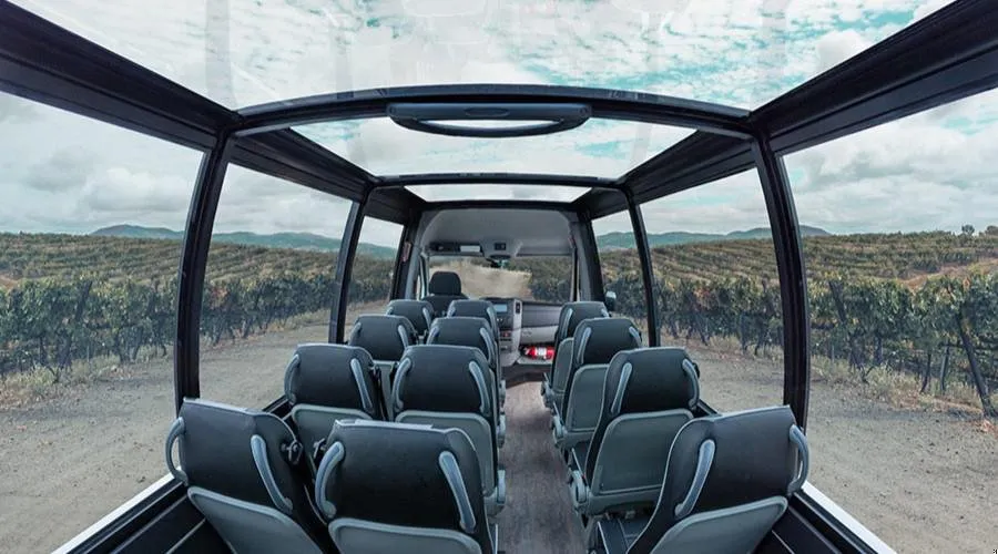 Interior view of a Mercedes convertible shuttle with a sprawling vista of vineyards 
