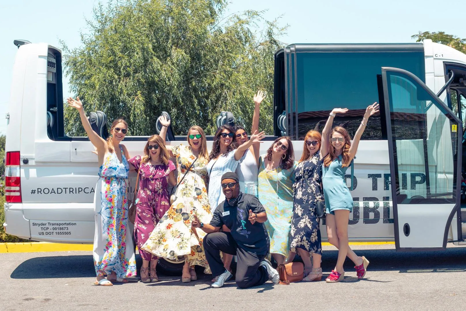 Grapeline guests celebrate in front of a convertible shuttle with their driver/wine country host.