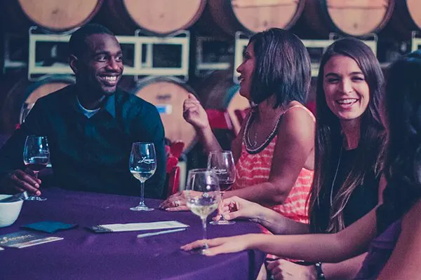 Guests sit together and enjoy a catered picnic lunch in a Barrel Tasting Room on a Sonoma Valley Wine Tour.